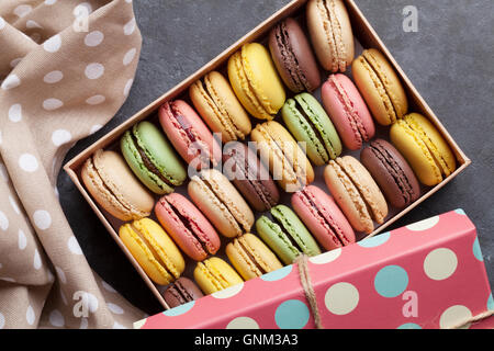 Bunte Macarons in einer Geschenkbox am Steintisch. Süßen Macarons. Ansicht von oben Stockfoto