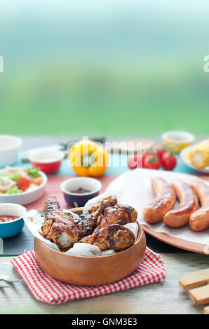 Auswahl an gegrillten Grillfleisch wie Huhn und Würstchen mit Salat Stockfoto