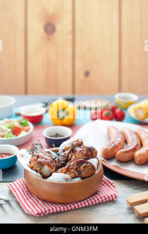 Auswahl an gegrillten Grillfleisch wie Huhn und Würstchen mit Salat Stockfoto