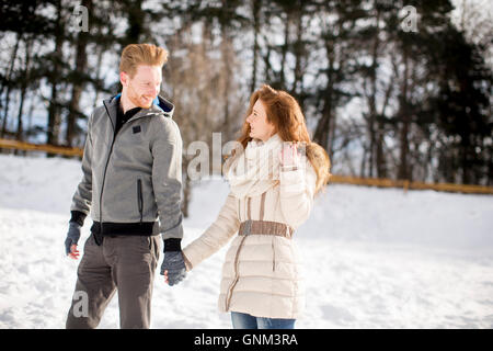 Junges Liebespaar bei Schnee im Winterwald Stockfoto