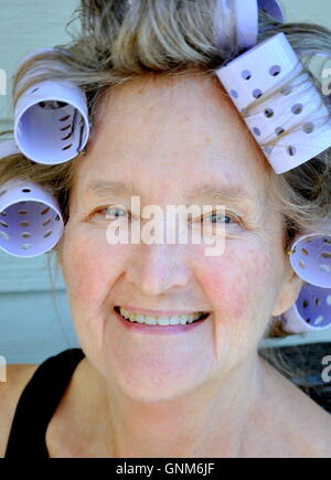 Weibliche Schönheit in Lockenwickler. Stockfoto