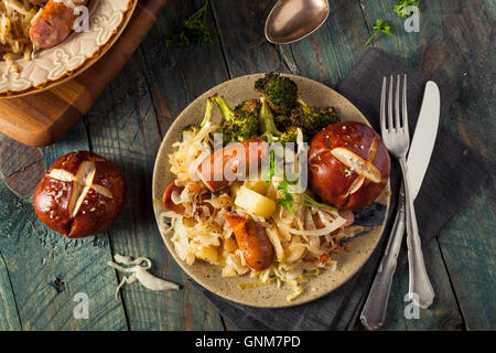 Hausgemachte deutsche Wurst und Sauerkraut mit einer Brezel Stockfoto