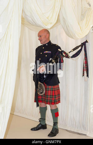 Schottische Piper am Eingang zur Hochzeit Festzelt, Preston Bissett, Buckinghamshire, England, Vereinigtes Königreich Stockfoto