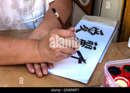 Der japanische Künstler, die Durchführung von Kalligraphie Stockfoto