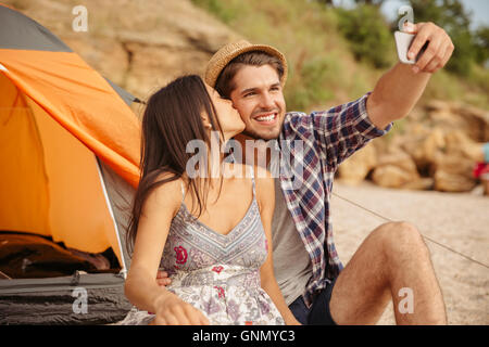 Glückliches junges Paar machen Selfie mit Smartphone und Spaß am Strand camping Stockfoto