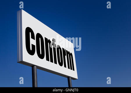 Große Anzeige-Panel, geprägt mit der Meldung 'CONFORM' gegen blauen Himmel. Stockfoto