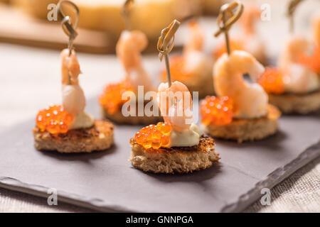 Shrimp Vorspeise serviert auf geröstetem Brot mit goldenen Kaviar Stockfoto