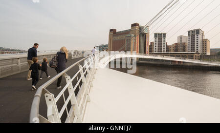 Gateshead Millennium Bridge - junge Familie zu Fuß über den Fluss Tyne in Richtung Ostsee-Zentrum für zeitgenössische Kunst Stockfoto