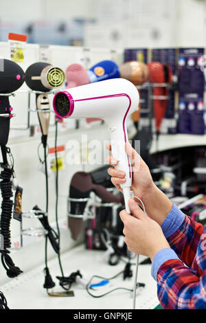 Frau wählt einen Haartrockner im store Stockfoto