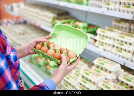 Die Verpackung in den Händen einer Frau Eiern im Supermarkt Stockfoto