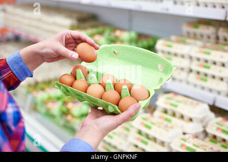 Die Verpackung in den Händen einer Frau Eiern im Supermarkt Stockfoto