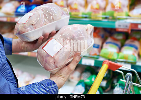 Käufer-Mann wählt Hühnerfleisch in einem Geschäft Stockfoto
