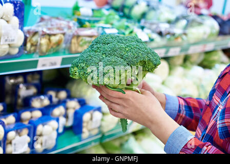 Frau kauft ein Brokkoli in einem Geschäft Stockfoto