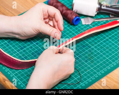 Lederverarbeitung - Skinner näht neue Ledergürtel Stockfoto