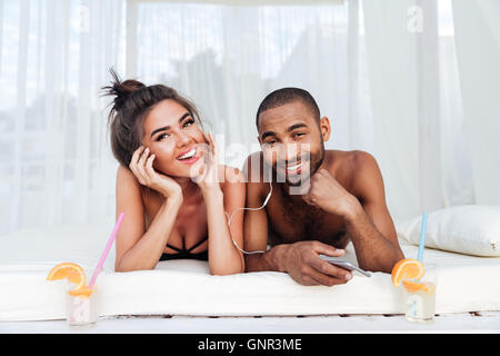 Junge glückliche Paar in Liebe Musikhören mit Kopfhörer am Strand Stockfoto