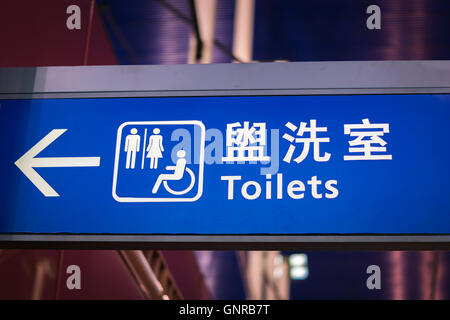 WC-Zeichen und Symbol für Männer, Frauen und Menschen mit Behinderungen, in Englisch und Chinesisch am Flughafen Stockfoto