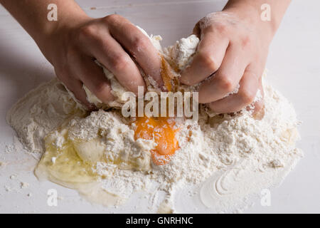 Rohteig machen von weiblichen Händen auf weißen Tisch Stockfoto