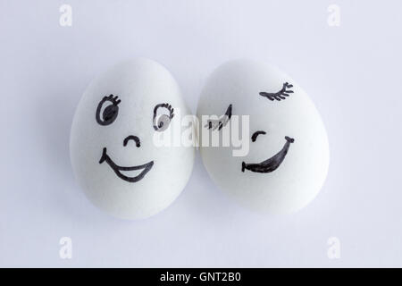 Lustigen weißen Eiern imitiert ein paar glücklich lächelnde Liebhaber auf weißem Hintergrund Stockfoto