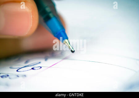 Menschliche Hand mit Stift auf weißem Papier, isoliert, Tiefenschärfe, geringe Schärfentiefe, Konzept der Business & Bildung. Stockfoto