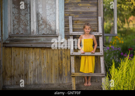 Ein kleines Mädchen in der Nähe das Dorfhaus. Stockfoto