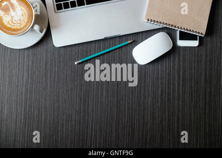 Draufsicht mit Kopie Raum schwarzen Schreibtisch Bürotisch mit Computer, Smartphone-Zubehör, Kaffeetasse. Stockfoto