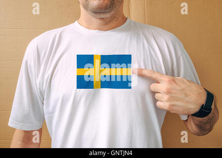 Gut aussehender Mann stolz tragen weiße T-shirt mit schwedischen Flagge bedruckt auf Brust, Konzept des Patriotismus Stockfoto