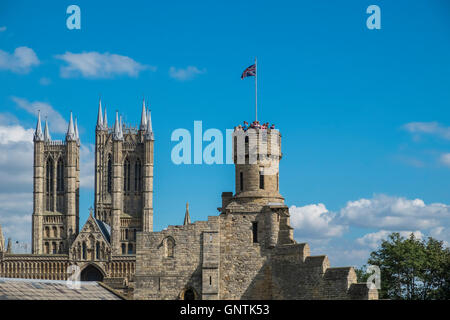 Alten Stadtmauern von Lincoln Castle, mit Touristen genießen die Aussicht auf die nahe gelegene Kathedrale von Lincoln aus dem Turm der Burg. Stockfoto