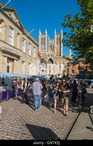 Menschen Surfen Castle Hill Markt Stände im historischen Stadt Lincoln, UK, mit Lincoln Kathedrale im Hintergrund. Stockfoto