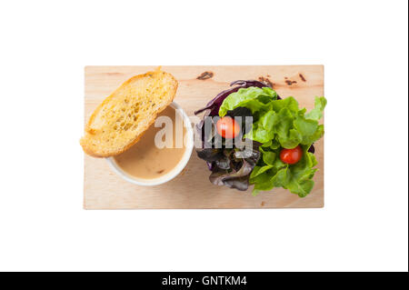 Draufsicht der Pilzsuppe in Keramik Tasse mit Toast und Freash Gemüse auf Holzplatte isoliert auf weißem Hintergrund. Sauber und Stockfoto