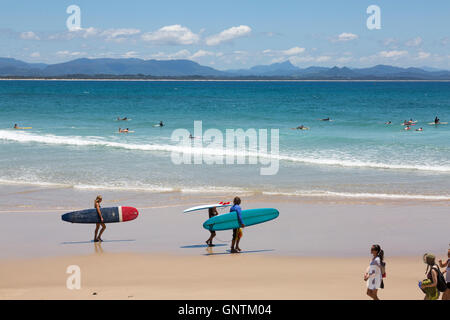 Surfer begeben sich am Sommertag in Byron Bay, New South wales, Australien zu den Wellen am Wategos Beach Stockfoto