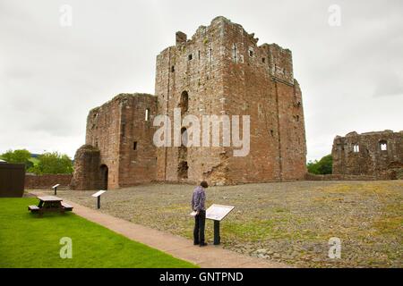 Brougham Castle halten. Frau touristische Zeichen betrachten. Penrith, Cumbria, England, Vereinigtes Königreich, Europa. Stockfoto