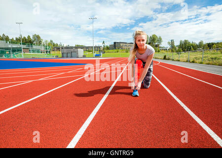 Selbstbewusste Frau, die Schnürsenkel zu binden, auf Laufstrecken Stockfoto
