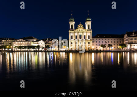 Die Lichter der Jesuiten-Kirche (Jesuitenkirche in deutscher Sprache) zu reflektieren in der Reuss in der Nacht in Luzern, Schweiz Stockfoto