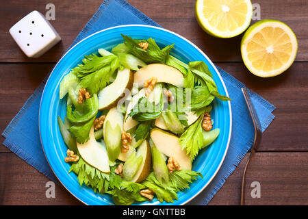 Frischem Sellerie, Birne und Walnuss Salat auf blaue Platte, Zitrone Hälften und Salzstreuer auf der Seite Stockfoto