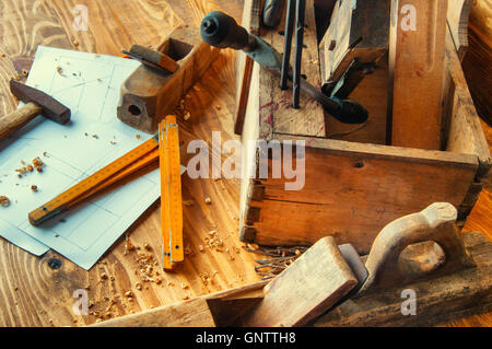 Ausrüstung-Zimmermann auf einem hölzernen Tisch mit Plänen. Stockfoto