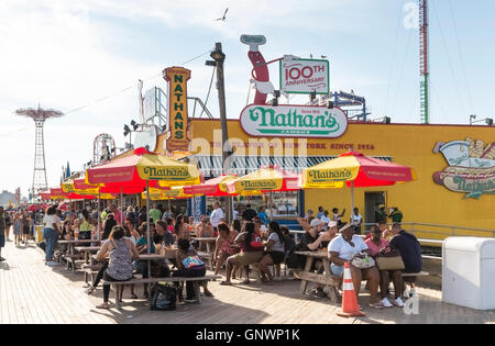 Außenansicht des legendären Nathan berühmte Hotdog gemeinsame auf Coney Island Boardwalk im Sommer, New York mit Menschen sitzen an Tischen Stockfoto