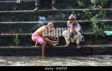 1. September 2016 - Kathmandu, Nepal - A hindu Anhänger führt religiöse Rituale mit Hilfe des Priesters während der Feier der Kuse Aunsi oder Vatertag, am Ufer des Bagmati Fluss in Gokarna-Tempel in Kathmandu,Nepal.Kuse Aunsi ist ein Hindu-Festival in die Väter, oder vorbei, sind auf den Neumond-Tag geehrt. (Kredit-Bild: © Sunil Sharma über ZUMA Draht) Stockfoto