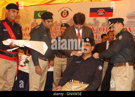 Hauptminister Sindh, Murad Ali Shah fixieren die Rangabzeichen auf den Schultern von Polizeibeamten in den Rang eines Deputy Superintendent der Polizei, während der Zeremonie befördert statt CPO in Karachi auf Donnerstag, 1. September 2016. Stockfoto