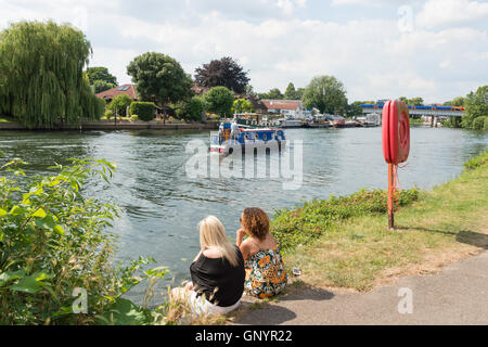 Frauen sitzen am Ufer der Themse in Staines-upon-Thames, Surrey, England, Vereinigtes Königreich Stockfoto