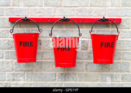 Drei Feuer Eimer an einer Wand hängen Stockfoto