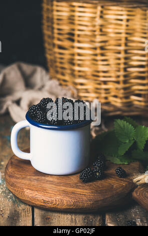 Frische Brombeeren in weiße Tasse auf die Runde Betreuung aus Holz Stockfoto