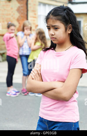 Unglückliche Mädchen wird durch Schulfreunde über geplaudert Stockfoto