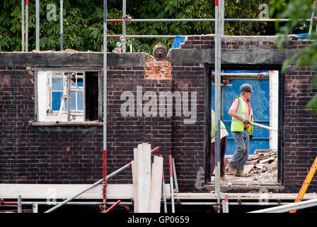 Zwei Arbeiter sehen durch den Eingang eines Gebäudes teilweise abgerissen Stockfoto