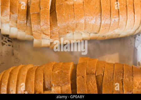 In Scheiben geschnitten Laib Brot im Korb, Ansicht von oben, Nahaufnahme. Geringe Schärfentiefe. Stockfoto