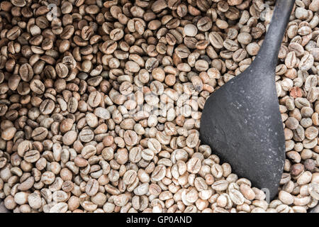 Grüne Kaffeebohnen mit einem alten Holzschale, bereit, geröstet werden. Stockfoto