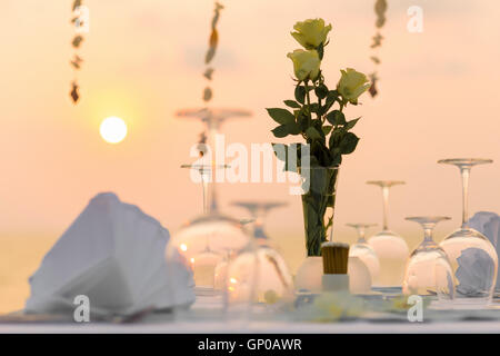 Einstellung der romantisches Abendessen am Strand bei Sonnenuntergang. Stockfoto