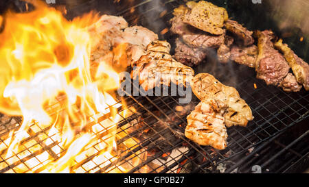 Verschiedene leckere Grillfleisch über der Flamme auf einem Grill Stockfoto