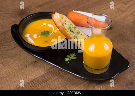 Karotten-Koriander-Suppe mit Knoblauchbrot Stockfoto