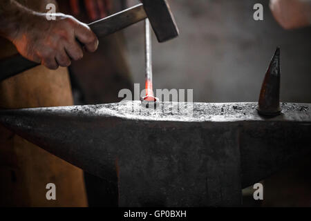 Dekoratives Element in der Schmiede auf dem Amboss zu machen Stockfoto