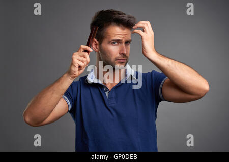 Eine schwere hübscher junger Mann seine Haare kämmen Stockfoto